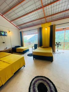 a bedroom with two beds and a large window at White Villa Kitulgala in Kitulgala