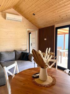 salon z kanapą i stołem z wazą w obiekcie Holiday Resort Zakątek Łeba w Łebie