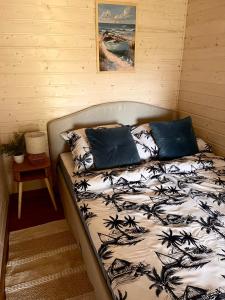 łóżko z 2 poduszkami w pokoju w obiekcie Holiday Resort Zakątek Łeba w Łebie
