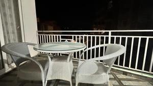a table and chairs sitting on a balcony at LivingStone Sky Hills Apartment Kasauli in Kasauli