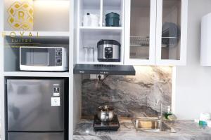a kitchen with a refrigerator and a microwave at Royal Suites Studio 6ZR - Kaina Tower at Nuvasa Bay in Pulau Nongsa