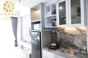 a kitchen with white cabinets and a stainless steel refrigerator at Royal Suites Studio 6ZR - Kaina Tower at Nuvasa Bay in Pulau Nongsa +8 photos