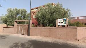un cancello con un cartello di fronte a un edificio di Dar badiawarda ad Azilal Altre 10 foto
