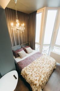 a bedroom with a bed and a chandelier at ATLANT luxury apartments ТЦ ДЕПОТ in Chernivtsi