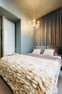 a bedroom with a large bed with a chandelier at ATLANT luxury apartments ТЦ ДЕПОТ in Chernivtsi