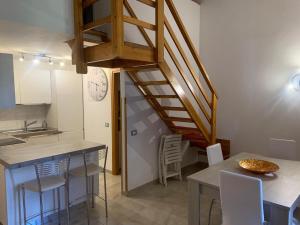 a kitchen with a staircase and a table with chairs at La Pigna in Marina di Sorso
