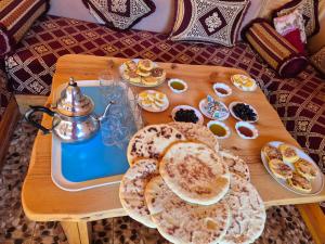 a table with a tray of pancakes and a tea kettle at badiawarda lodge in Azilal