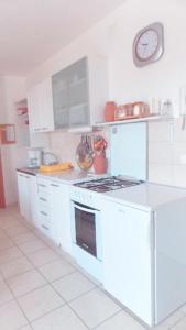 a kitchen with white appliances and a clock on the wall at Olive Hideout in Gajac +12 photos