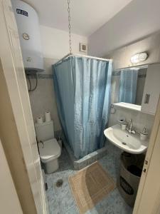 a small bathroom with a toilet and a sink at Sea view apartment in Paralion astros
