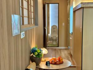 東京にあるTOKYO SKYTREE HOUSE-Multiple room stylesの花が飾られたテーブルとトイレのある部屋