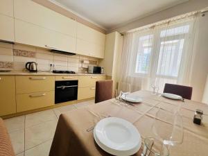 a kitchen with a table with plates and glasses on it at ASTER Home !! in Chişinău
