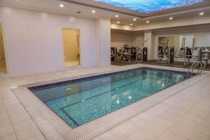 a swimming pool in a house with a gym at Haden Hotel in Erbil
