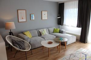 un salon avec un canapé et une table dans l'établissement Ferienhaus Nr 128, Kategorie Komfort Plus L, Feriendorf Hochbergle, Allgäu, à Lechbruck am See