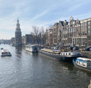 een rivier met boten in een stad met gebouwen bij Houseboat Reussi in Amsterdam