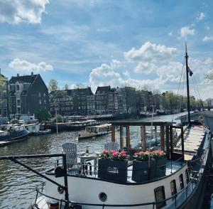 een boot ligt aangemeerd in het water met bloemen erop bij Houseboat Reussi in Amsterdam