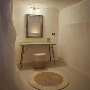 a bathroom with a table with a mirror and a rug at Selora Cave in Pyrgos +13 photos