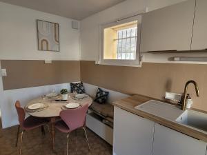 a small kitchen with a table and chairs and a couch at Appartement de charme dans une maison de maître in Surgères