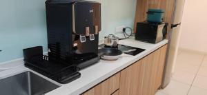 encimera de cocina con cafetera y microondas en Sunway Geo Premium Suites CEA0 at Sunway City by Ezprop, en Subang Jaya 2 fotos más