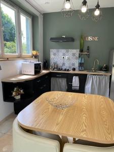 a kitchen with a wooden table and a counter top at Charmant Logis a la campagne in Ardentes +11 photos