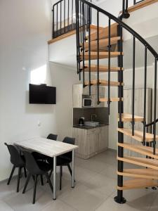 a dining room with a table and a spiral staircase at Apartamenty Wilczyca in Wilczyn