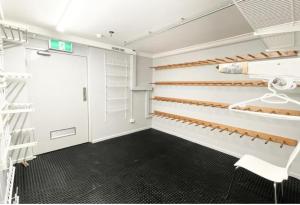 a walk in closet with white walls and wooden shelves at Shamrock Apartment 9 - Mount Hotham in Mount Hotham