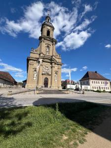a building with a clock tower on a street at TOP LAGE 2 Personen Volkach Wohnwagen Luxus in Volkach