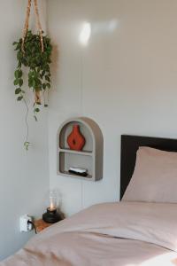 a bedroom with a bed with a clock on the wall at Badhuisje aan Zee op Huisduinen in Huisduinen