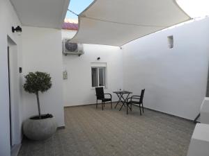a patio with a table and chairs and a potted tree at Angelica Residence - Perfect Quiet Center Location - 10mins Walk to Gennadi Beach in Gennadi