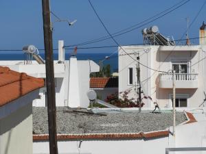 a view of a white building with the ocean in the background at Angelica Residence - Perfect Quiet Center Location - 10mins Walk to Gennadi Beach in Gennadi