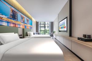 a hotel room with four beds and a flat screen tv at Norman Hotel in Guangzhou