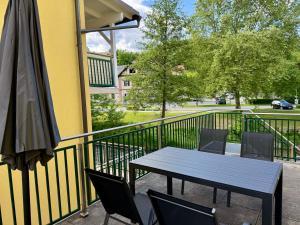 a table and chairs on a balcony with an umbrella at Haus Am Fluss in Deutschlandsberg