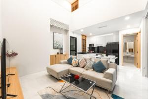 un salon avec un canapé et une table dans l'établissement V190 Tropical Oasis 3BR Villa with Pool & Bathtub, à Ban Saiyuan (1)