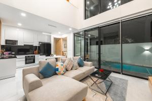 un salon avec un canapé et une cuisine dans l'établissement V190 Tropical Oasis 3BR Villa with Pool & Bathtub, à Ban Saiyuan (1)