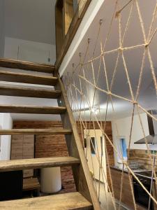 a wooden staircase in a room with a net at Le Ronfleur du Hérou in Houffalize +4 photos