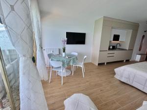 a room with a table and chairs and a bedroom at Casa Sud Menton vue mer exceptionnelle terrasse parking inclus climatisation in Menton