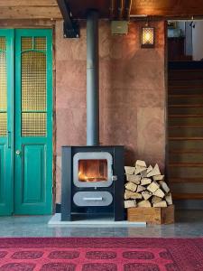 a stove with a pile of wood next to a door at otto7senses in Haifa