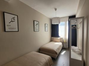 a small room with two beds and a mirror at Immeuble du Mausolée in Rabat