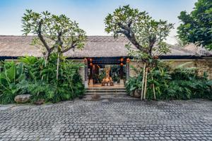 een huis met een binnenplaats met bomen bij Radha Phala Resort & Spa in Ubud