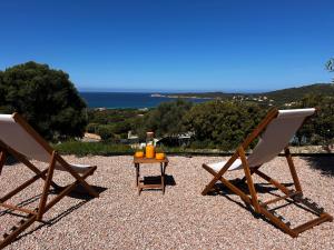 two chairs and a table with oranges on it at Appartement vue mer Vulpaghja 01 in Cargèse