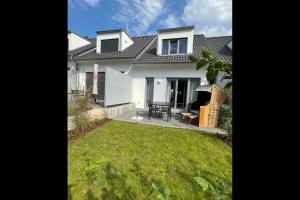 een wit huis met een gazon ervoor bij Bernsteinquartier BQ6b - Haus Lachmöwe in Kolpinsee