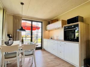 Una cocina y un comedor con mesa y sillas. en Ferienhaus "die Müllerei" 11 Feriendorf Klein Stresow Rügen by ruyastay, en Putbus 21 fotos más