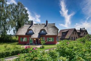 una casa con techo gris y rojo en Ferienhaus "die Müllerei" 11 Feriendorf Klein Stresow Rügen by ruyastay, en Putbus