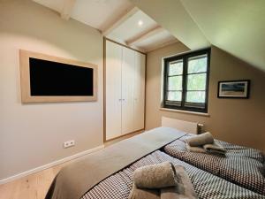 Un dormitorio con una cama y un televisor de pantalla plana. en Ferienhaus "die Müllerei" 11 Feriendorf Klein Stresow Rügen by ruyastay, en Putbus