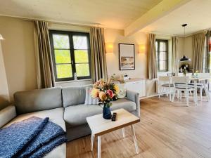 una sala de estar con un sofá y una mesa en Ferienhaus "die Müllerei" 11 Feriendorf Klein Stresow Rügen by ruyastay, en Putbus