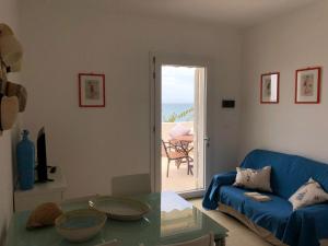 a living room with a blue couch and a table at Casa fronte mare a Torre Vado 2 in Torre Vado