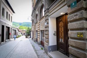 a person walking down a street next to a wooden door at Old Town Whisper Apartments in Sarajevo