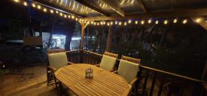 einen Holztisch und Stühle auf einer Veranda mit Beleuchtung in der Unterkunft Vomer Beachside Unit in Pakoštane + 52 Fotos