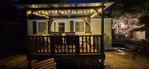 ein Haus mit einer Veranda, die beleuchtet ist in der Unterkunft Vomer Beachside Unit in Pakoštane
