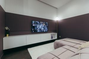 a bedroom with two beds and a tv on the wall at ATLANT luxury Premium apartments ТЦ ДЕПОТ in Chernivtsi