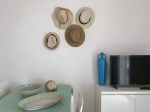 a table with hats on the wall and a tv at Casa fronte mare a Torre Vado 2 in Torre Vado